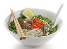 A bowl of pho, made with white rice stick noodles.