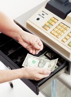 A cashier takes cash from a customer for a transaction.