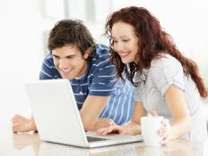 A couple using a laptop with an LCD screen.