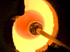 Glass blower heating glass in a kiln