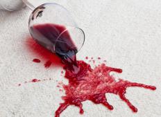 Glass of red wine spilled on a white carpet