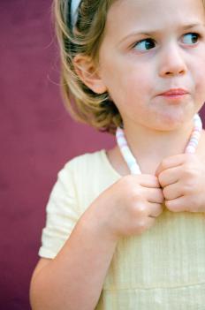 A girl wearing a candy necklace that she made.