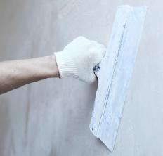A plasterer applies a finish coating to a wall.