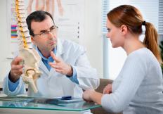 A chiropractor talking to a patient.