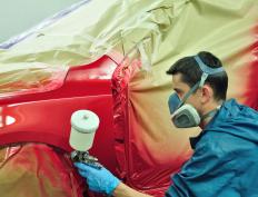 An auto body mechanic painting a car.