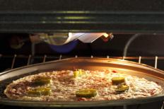 A pizza broiling in an oven.