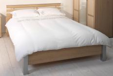 A bed with a duvet on it.