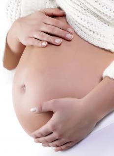 A pregnant woman holding her stomach.