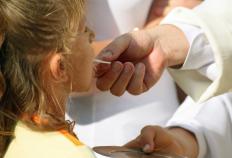 A Christian pastor giving communion to a girl.