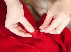 A person sewing a button.