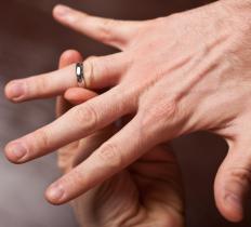 A person pushing a ring over his knuckle joint.