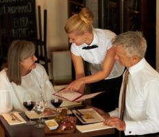 A waitress explains the menu to her customers.