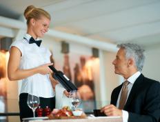 Waitress showing a bottle of wine to a customer