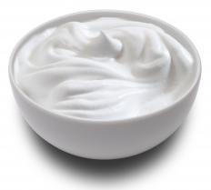 A bowl of sour cream, which can add moisture to brownie muffins.