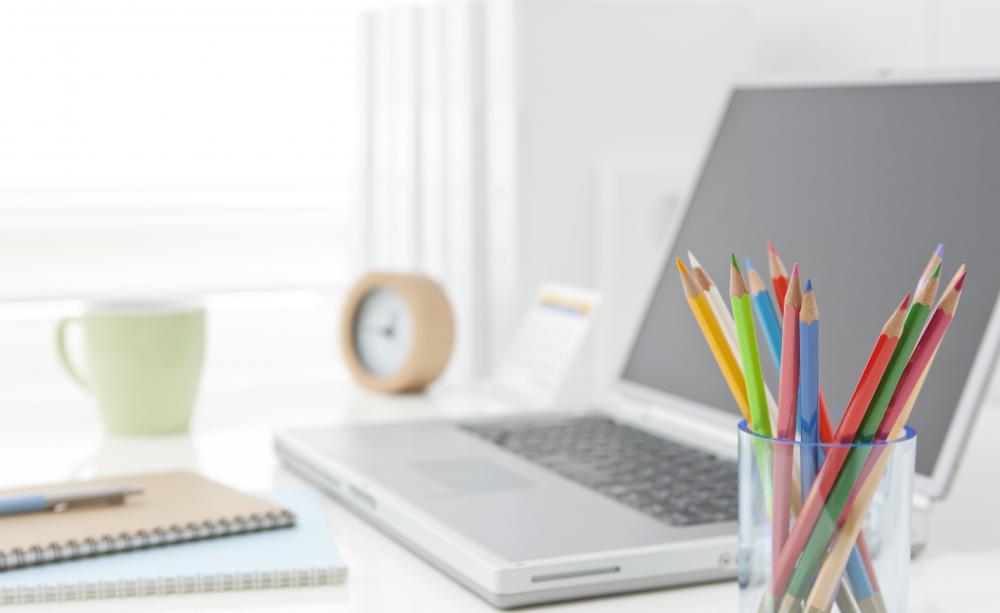 https://images.wisegeek.com/a-green-cup-clock-computer-and-clear-jar-of-colored-pencils.jpg