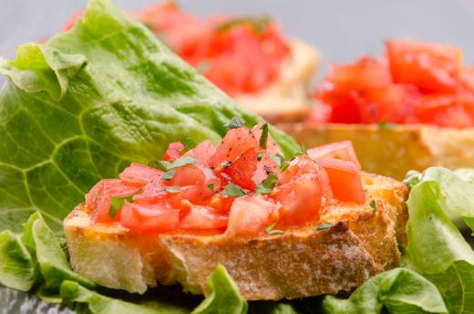 Bruschetta salad includes a green salad with bread or croutons and bruschetta on top.