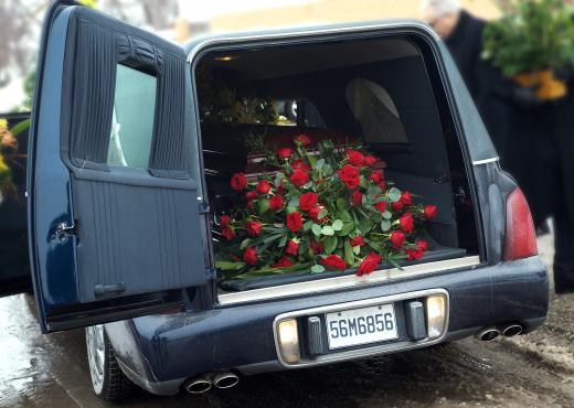 Pallbearers carry the coffin from the hearse to the facility where the funeral is to be held.