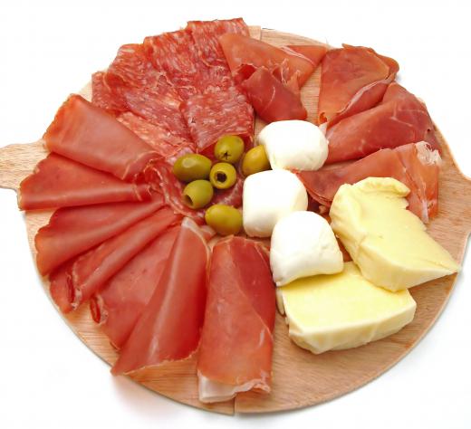 Classic antipasto platter including parma ham and salami along with olives and assorted varieties of cheese.