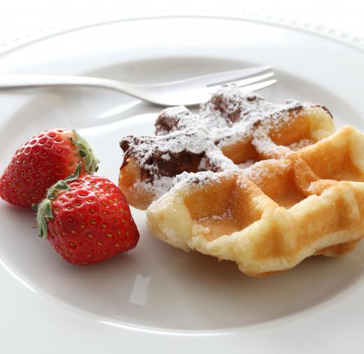 Waffles with chocolate syrup and confectioner's sugar.