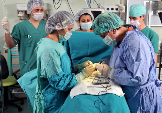 A circulating nurse monitors procedure in an operating room.