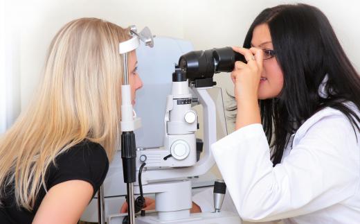 An optometrist uses a slit lamp machine to examine a patient's eyes.