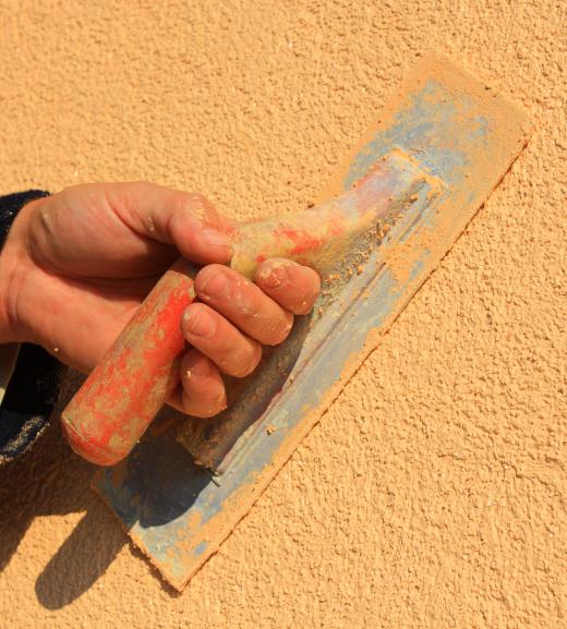 A person repairing stucco.