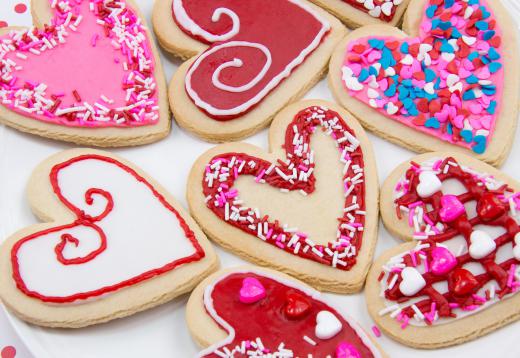 Frosted, heart-shaped cookies are versatile decorations that can also be eaten.