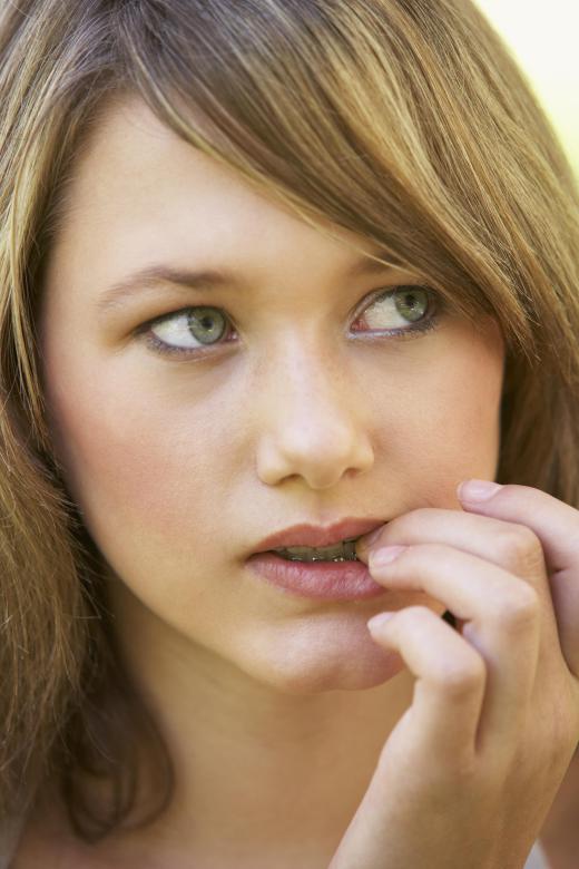 A girl with stereotypic movement disorder biting her nails.