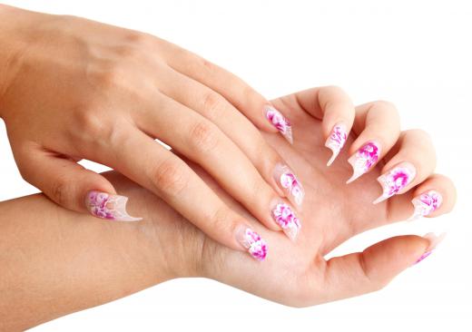 A woman with acrylic fingernails with nail art on them.