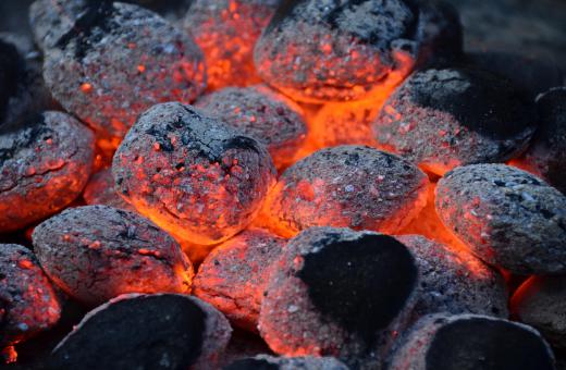 Hot charcoal briquettes in a grill.