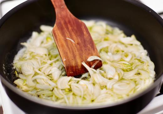 Saute evenly sliced onions in butter or oil for 15 minutes to begin making an onion tart.