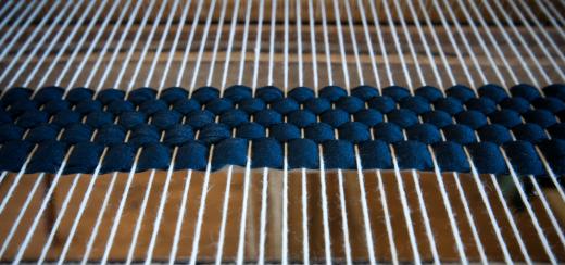 A loom helps crafters weave yarn into patterns.