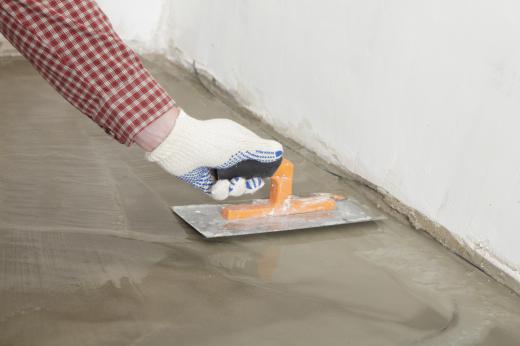 A man smoothing out a concrete garage floor.