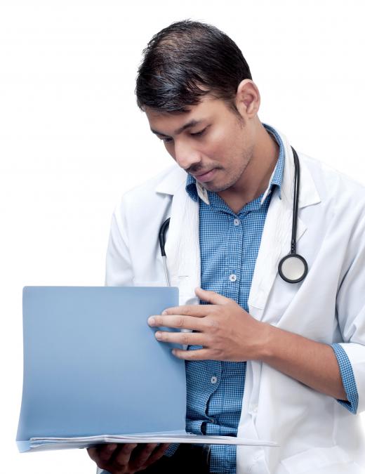 A medical reimbursement specialist collects medical charts filled out by doctors and enters the new information into a computer database.