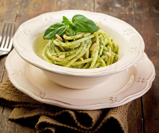 Pasta with pesto sauce, topped with pine nuts.