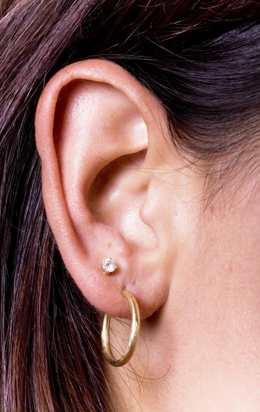 A woman wearing gold earrings.