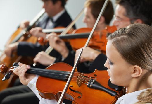 A violin tutor provides instruction to violin students.