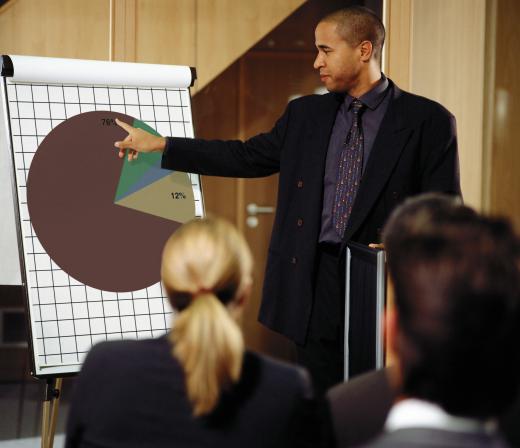 A sales coordinator with a pie chart discussing sales figures with colleagues.