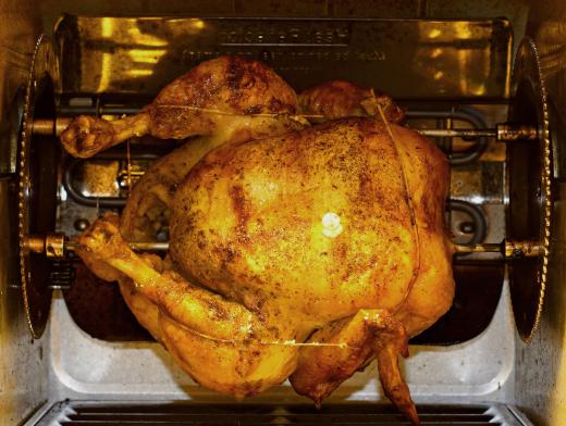 A rotisserie cooks food by holding it on a spit over a flame or heating element and continuously rotating it.