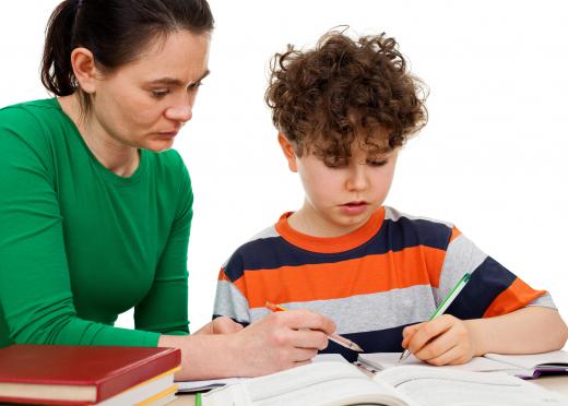 A primary school tutor helps children with homework.