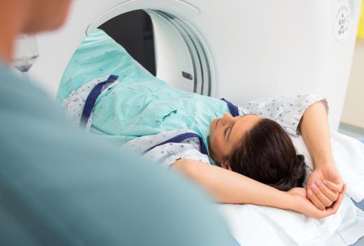 During a CT scan, patients lie flat on a table while the machine passes over them collecting images.