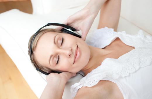 Woman listening to soothing music in bed.