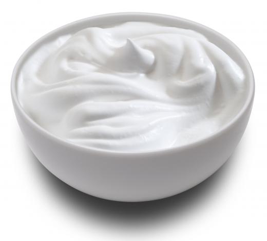 A bowl of sour cream, which is often served alongside chicken tortilla casserole.